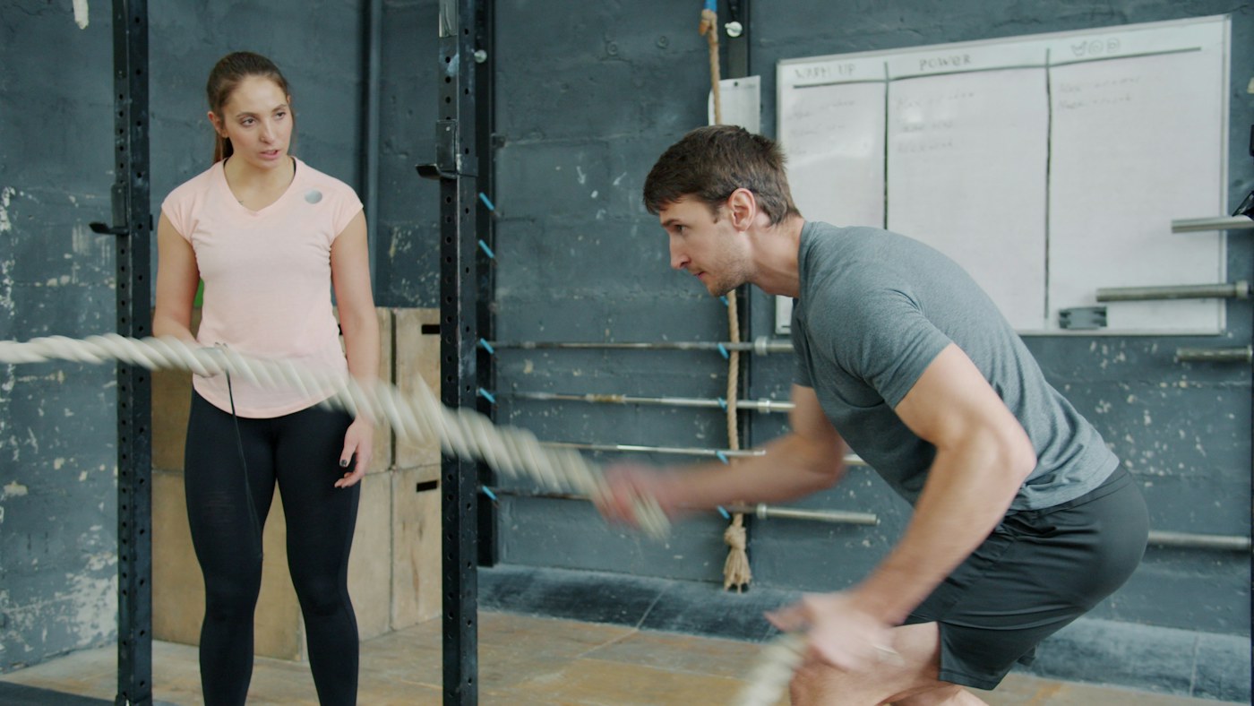 People exercise together in a coached gym session.
