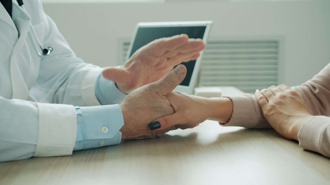A clinician offers a patient reassurance during a conversation.